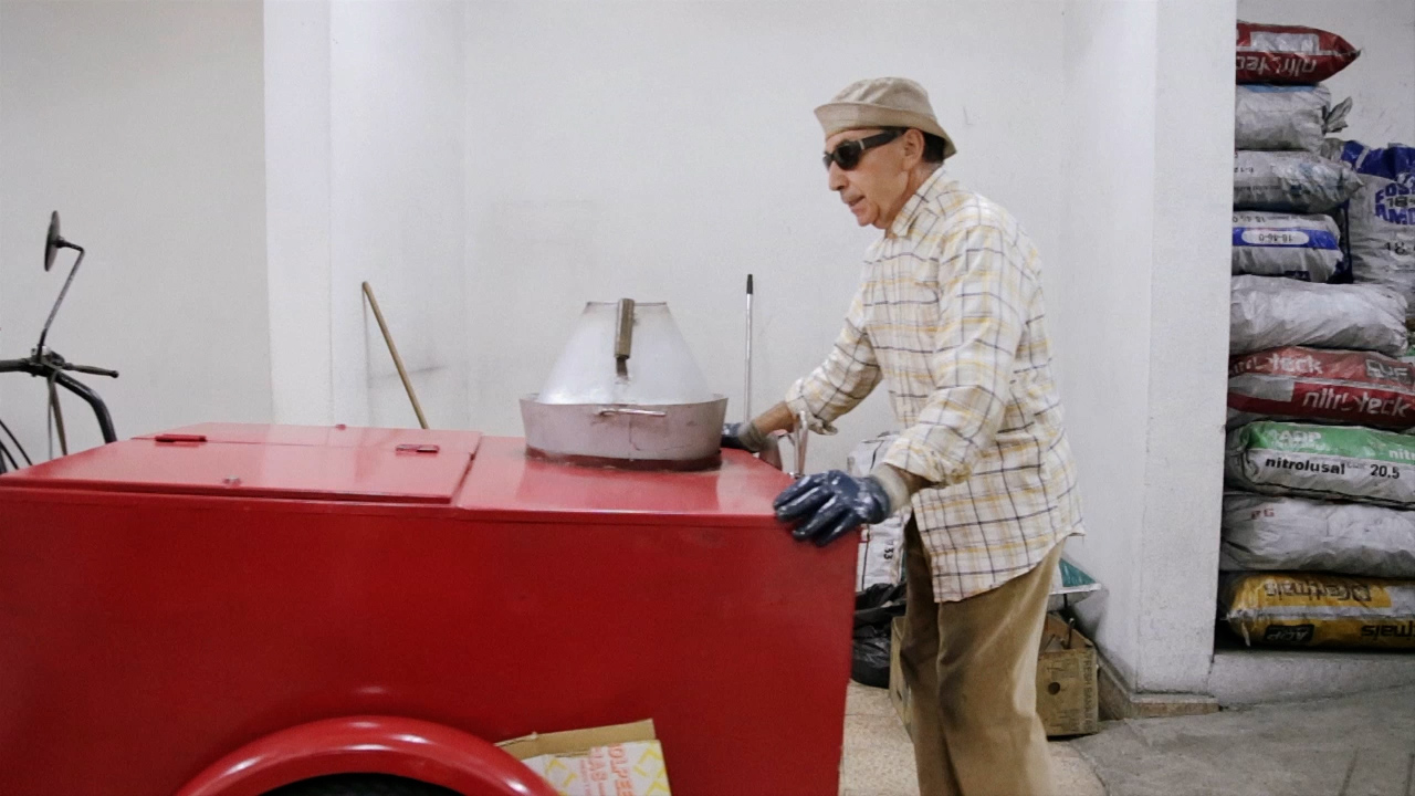 O vendedor junto ao carrinho de castanhas